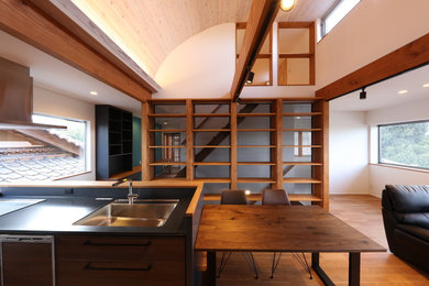 Example of a small minimalist single-wall brown floor open concept kitchen design in Other with open cabinets, an island, an undermount sink, black cabinets, solid surface countertops, brown backsplash, wood backsplash, paneled appliances and black countertops