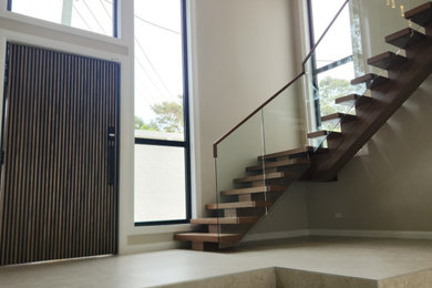 Design ideas for a small contemporary front door in Sydney with porcelain floors, a single front door, a dark wood front door and beige floor.