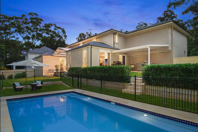 Large contemporary backyard rectangular lap pool in Sydney with natural stone pavers.