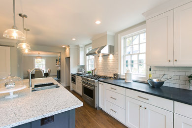 Inspiration for a traditional kitchen in Philadelphia with an undermount sink, shaker cabinets, white cabinets, quartz benchtops, white splashback, subway tile splashback, stainless steel appliances, medium hardwood floors, with island and brown floor.
