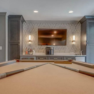 Foto di un angolo bar senza lavandino stile marinaro di medie dimensioni con nessun lavello, ante con riquadro incassato, ante grigie, top in quarzo composito, paraspruzzi grigio, pavimento in travertino, pavimento beige e top bianco