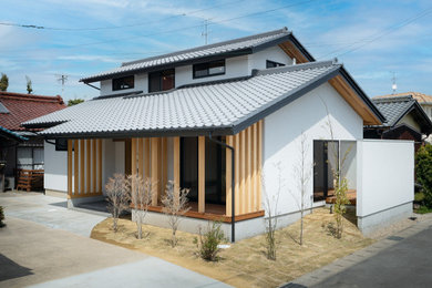 Idées déco pour une petite façade de maison blanche à un étage avec un toit à deux pans, un toit en tuile et un toit gris.