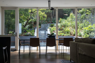 Design ideas for a mid-sized contemporary partial sun and drought-tolerant backyard stone and wood fence retaining wall landscape in San Francisco.