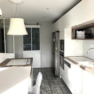 Cuisine blanche et bois ouverte par une verrière sur le salon