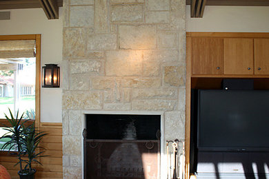 Example of a living room design in Dallas with a standard fireplace, a stone fireplace and a tv stand