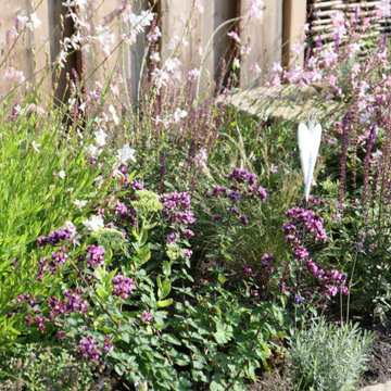 Insektenfreundlicher Garten mit Natursteinmauern und tiefergelegtem Sitzplatz