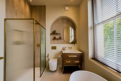 This is an example of a medium sized traditional family bathroom in London with beaded cabinets, dark wood cabinets, a freestanding bath, a walk-in shower, a wall mounted toilet, an open shower, a wall niche, a single sink and a freestanding vanity unit.
