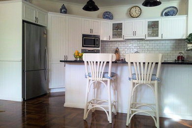 Photo of a country kitchen in Sunshine Coast with white cabinets.