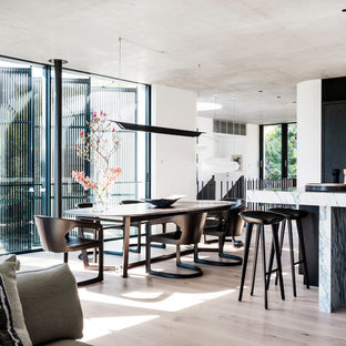 Offenes, Großes Modernes Esszimmer mit weißer Wandfarbe, hellem Holzboden, Kaminsims aus Holz und beigem Boden in Sydney