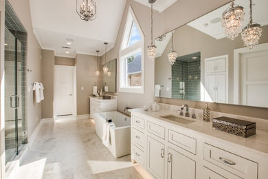 Example of a large transitional master glass tile marble floor and white floor bathroom design in Dallas with recessed-panel cabinets, white cabinets, gray walls, an undermount sink, marble countertops, a hinged shower door and white countertops
