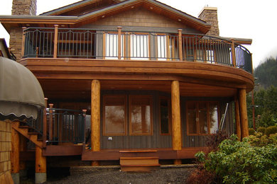 Photo of a mid-sized arts and crafts two-storey grey house exterior in Vancouver with wood siding, a gable roof and a shingle roof.