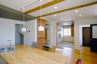 Стильный дизайн: гостиная-столовая среднего размера в современном стиле с белыми стенами, деревянным полом, балками на потолке и обоями на стенах - последний тренд