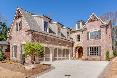 Large elegant red two-story brick exterior home photo in Atlanta