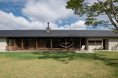 Imagen de fachada de casa escandinava de una planta con tejado a dos aguas y tejado de teja de barro