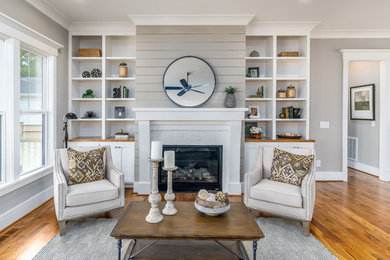 Country formal and open concept medium tone wood floor and brown floor living room photo in Raleigh with gray walls and a standard fireplace