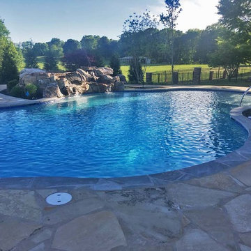 Pool with boulder waterfall and flagstone pool deck.