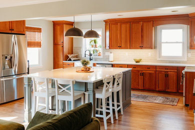 Enclosed kitchen - mid-sized transitional u-shaped medium tone wood floor and brown floor enclosed kitchen idea in Philadelphia with a farmhouse sink, shaker cabinets, medium tone wood cabinets, quartz countertops, green backsplash, ceramic backsplash, stainless steel appliances, an island and white countertops