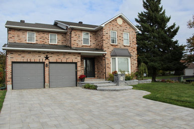 Photo of a mid-sized traditional front yard full sun driveway for summer in Ottawa with a garden path and brick pavers.