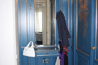 他の地域にある広いトラディショナルスタイルのおしゃれな壁面クローゼット (レイズドパネル扉のキャビネット、青いキャビネット、磁器タイルの床) の写真