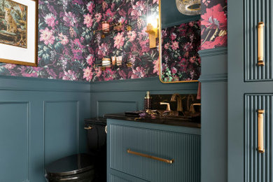 Powder room - small traditional ceramic tile and brown floor powder room idea in Minneapolis with furniture-like cabinets, green cabinets, a two-piece toilet, multicolored walls, a drop-in sink, quartz countertops and black countertops