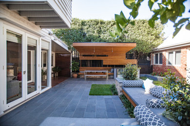 Inspiration for a small contemporary backyard patio in Melbourne with natural stone pavers.