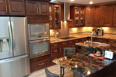 Design ideas for a large transitional l-shaped separate kitchen in Philadelphia with a farmhouse sink, raised-panel cabinets, medium wood cabinets, granite benchtops, beige splashback, stone tile splashback, stainless steel appliances, porcelain floors, with island and beige floor.