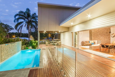 Mid-sized contemporary backyard rectangular lap pool in Brisbane with decking.