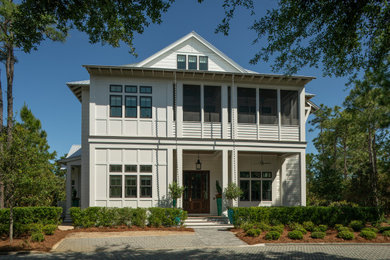 Inspiration for a coastal white three-story wood and board and batten exterior home remodel in Other with a metal roof and a gray roof
