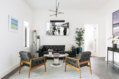 Example of a large minimalist formal and open concept concrete floor and gray floor living room design in Charleston with white walls and a wall-mounted tv
