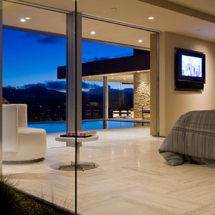 Photo of a large modern master bedroom in San Francisco with beige walls, travertine floors and no fireplace.