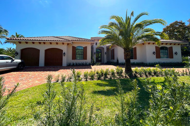 Mid-sized white one-story stucco house exterior photo in Miami with a hip roof, a tile roof and a brown roof