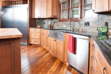 Inspiration for a mid-sized timeless u-shaped medium tone wood floor eat-in kitchen remodel in Other with a double-bowl sink, shaker cabinets, medium tone wood cabinets, granite countertops, multicolored backsplash, stone tile backsplash, stainless steel appliances and an island