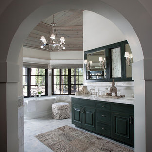 Country bathroom in Sacramento with raised-panel cabinets, a freestanding tub and white walls.