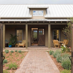 Mittelgroßes, Einstöckiges, Beigefarbenes Country Einfamilienhaus mit Lehmfassade, Satteldach und Blechdach in Albuquerque