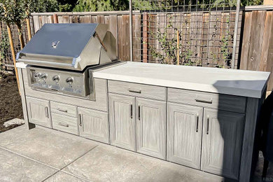 Example of a small transitional single-wall slate floor and gray floor kitchen design in San Francisco with shaker cabinets, gray cabinets, solid surface countertops, stainless steel appliances and white countertops