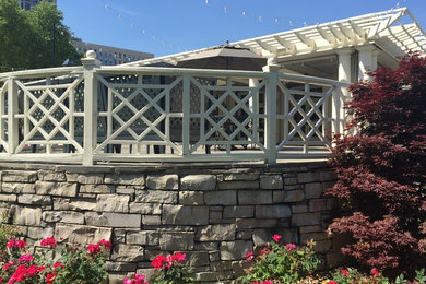 Example of a mid-sized trendy backyard stone patio design in Chicago with a pergola