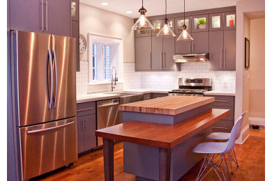 Minimalist l-shaped eat-in kitchen photo in Other with a farmhouse sink, flat-panel cabinets, gray cabinets, wood countertops, white backsplash, subway tile backsplash and stainless steel appliances