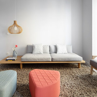 Imagen de salón contemporáneo con suelo de madera en tonos medios y paredes blancas