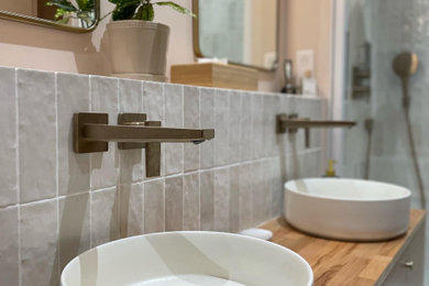 This is an example of a large scandi ensuite bathroom in Lyon with a submerged bath, white tiles, pink walls, a built-in sink, wooden worktops, a sliding door, double sinks, a built in vanity unit, beaded cabinets, light wood cabinets, a two-piece toilet, terracotta tiles, ceramic flooring, beige floors and beige worktops.