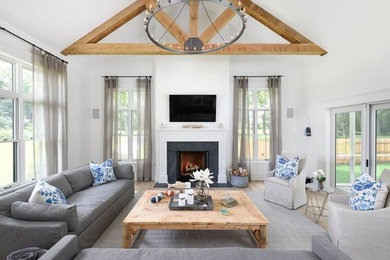 Inspiration for a cottage light wood floor family room remodel in Chicago with white walls, a standard fireplace and a wall-mounted tv