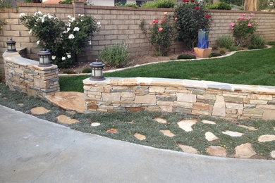 Photo of a mid-sized country front yard garden in Los Angeles with natural stone pavers.