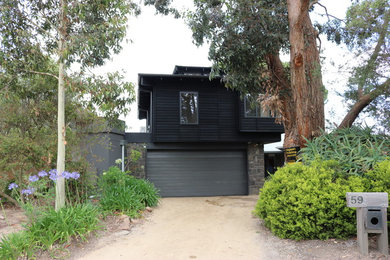 Inspiration for a contemporary black exterior in Melbourne with wood siding.
