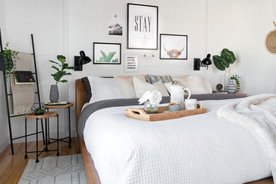 Bedroom - mid-sized farmhouse guest light wood floor bedroom idea in Other with white walls