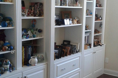 Example of a large classic enclosed dark wood floor living room library design in Other with white walls, no fireplace and no tv