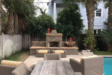 This is an example of a mid-sized contemporary backyard patio in Miami with a fire feature and natural stone pavers.