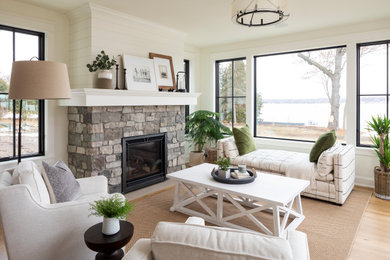 Inspiration for a coastal light wood floor sunroom remodel in Minneapolis with a standard fireplace, a stone fireplace and a standard ceiling