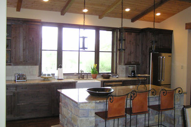 Mountain style l-shaped kitchen photo in Dallas with a farmhouse sink, medium tone wood cabinets, stainless steel appliances and an island