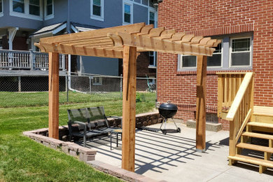 Example of a mid-sized classic backyard concrete patio design in Omaha with a pergola