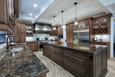 Inspiration for a large traditional u-shaped separate kitchen in Toronto with a double-bowl sink, raised-panel cabinets, dark wood cabinets, granite benchtops, white splashback, subway tile splashback, stainless steel appliances, porcelain floors, with island and multi-coloured floor.