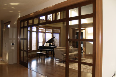 Living room - mid-sized traditional formal and enclosed medium tone wood floor living room idea in Calgary with beige walls, no fireplace and no tv